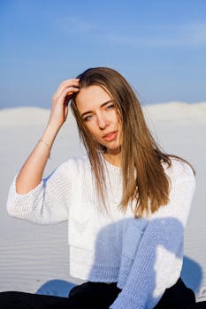 一位时尚女性在阳光明媚的沙漠中摆出轻松迷人的姿势