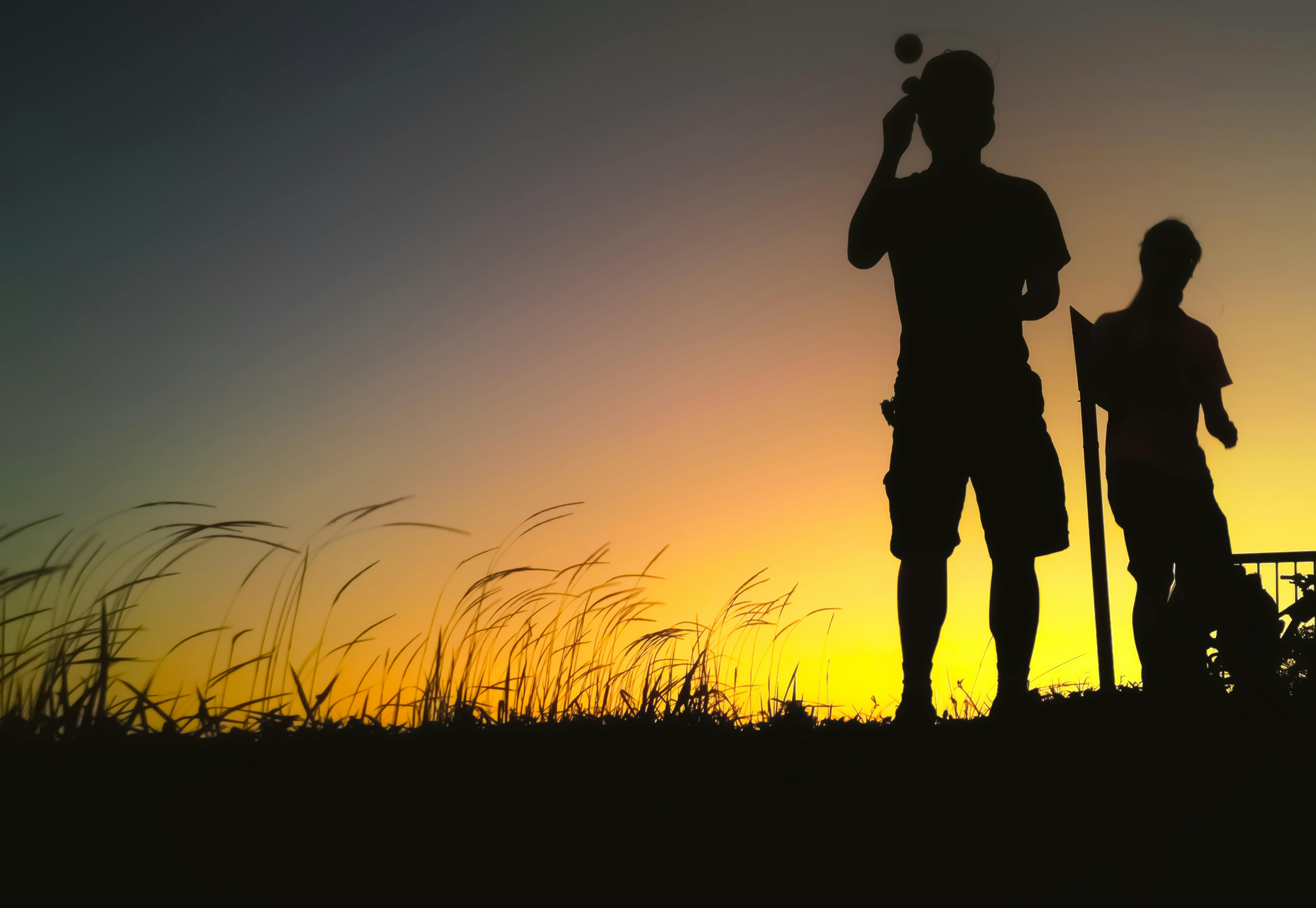 剪影中的人站在一个充满活力的香港日落下的领域里