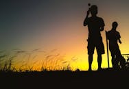 剪影中的人站在一个充满活力的香港日落下的领域里