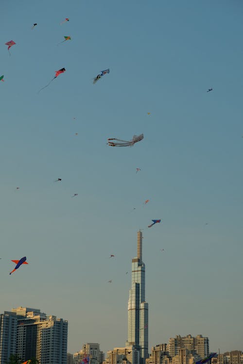 A city skyline with many kites flying in the sky