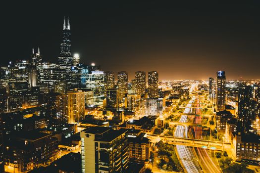 A breathtaking view of Chicago's illuminated skyline and busy highways at night.
