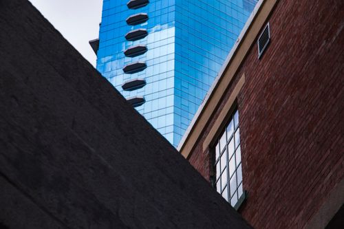Free A striking image capturing the contrast between modern glass skyscrapers and traditional brick buildings in Hong Kong. Stock Photo