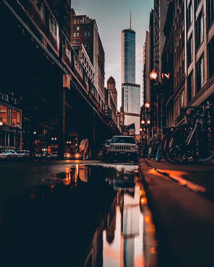 Reflection Of Vehicle On Water On Sidewalk