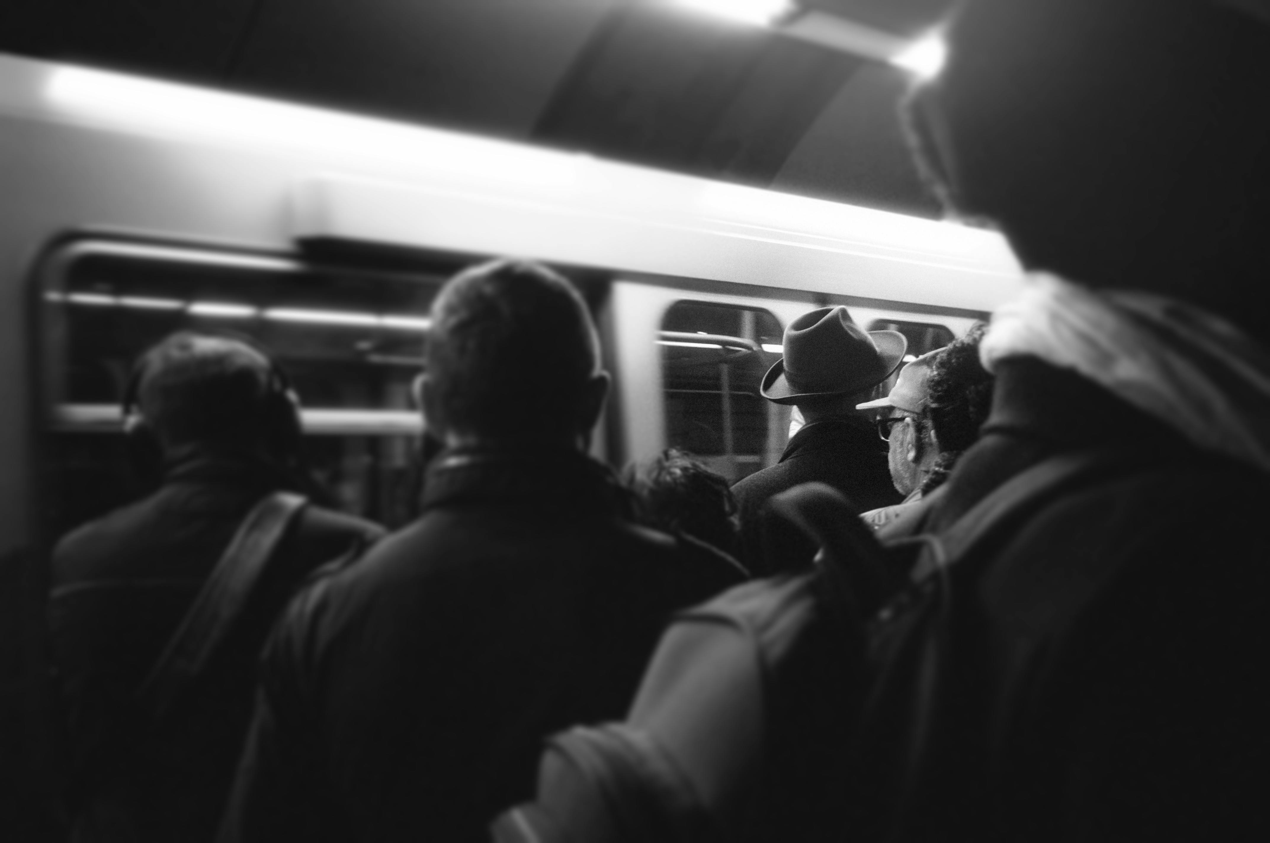 grayscale photography of people standing near train