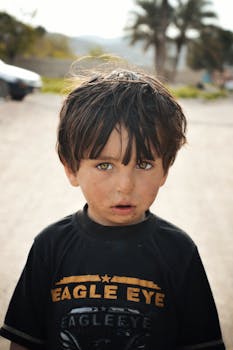 巴基斯坦农村地区，一个小男孩站在户外的肖像，展现了天真与好奇