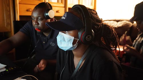 Two women wearing face masks and headphones