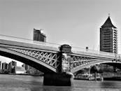 一张黑白照片，戏剧性地展现了桥梁与城市天际线，非常适合城市建筑主题