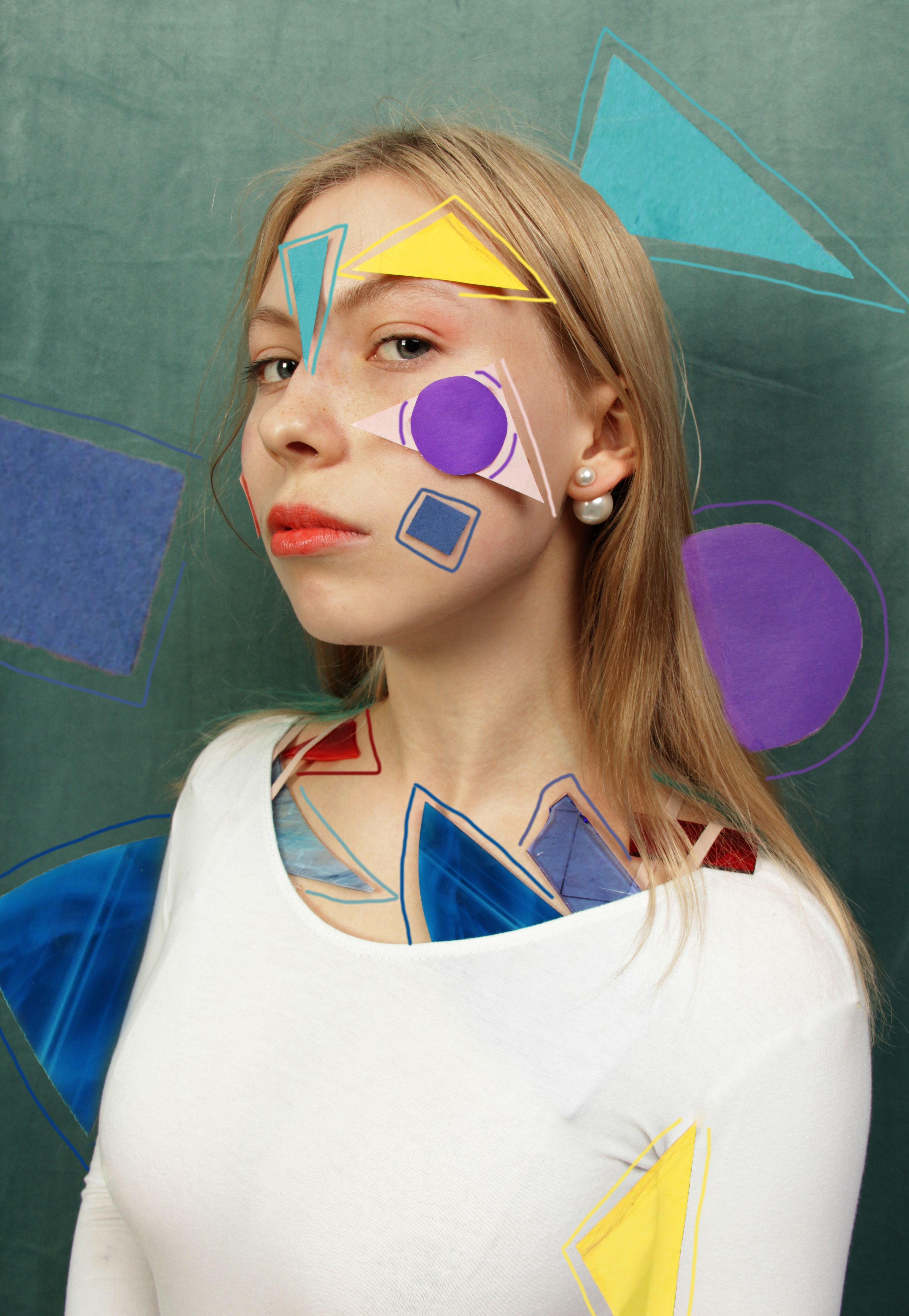 Creative portrait of a woman with colorful geometric designs on face and background.