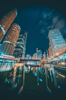 夜间，芝加哥的城市天际线倒映在河中，展现了现代建筑的魅力