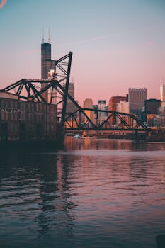 日落时分，芝加哥河上标志性铁路桥与城市天际线构成了一幅美景