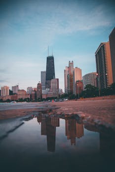 黄昏时分，芝加哥天际线倒映在街道的水坑中