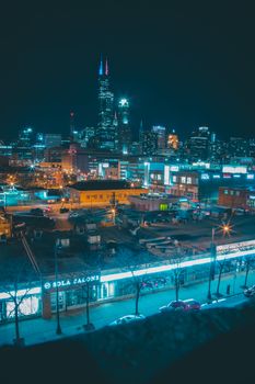 Chicago skyline brightly illuminated at night, featuring skyscrapers and urban nightlife.