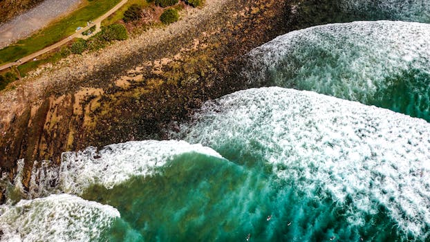 Aerial shot of waves crashing on the rocky shore at Crescent Head, Australia.