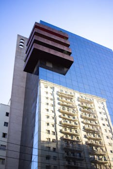 现代摩天大楼映照出另一栋建筑的风貌，展现了当代城市建筑的特色