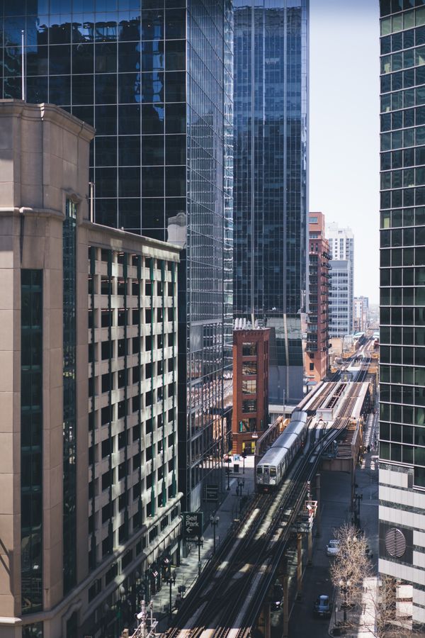 Elevated L train running between downtown Chicago skyscrapers