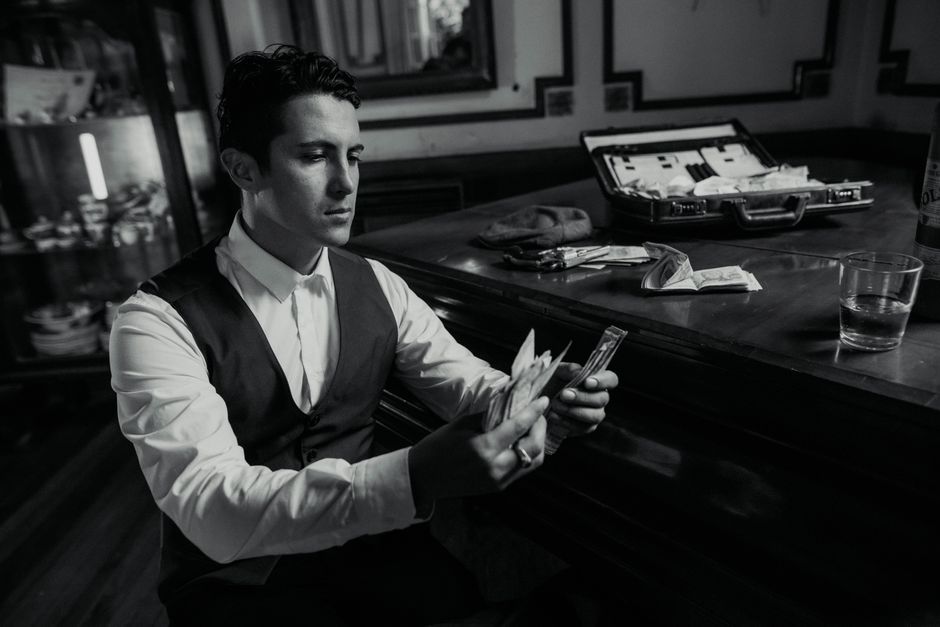 A fashionable man in Buenos Aires counts money, evoking a classic mobster vibe.