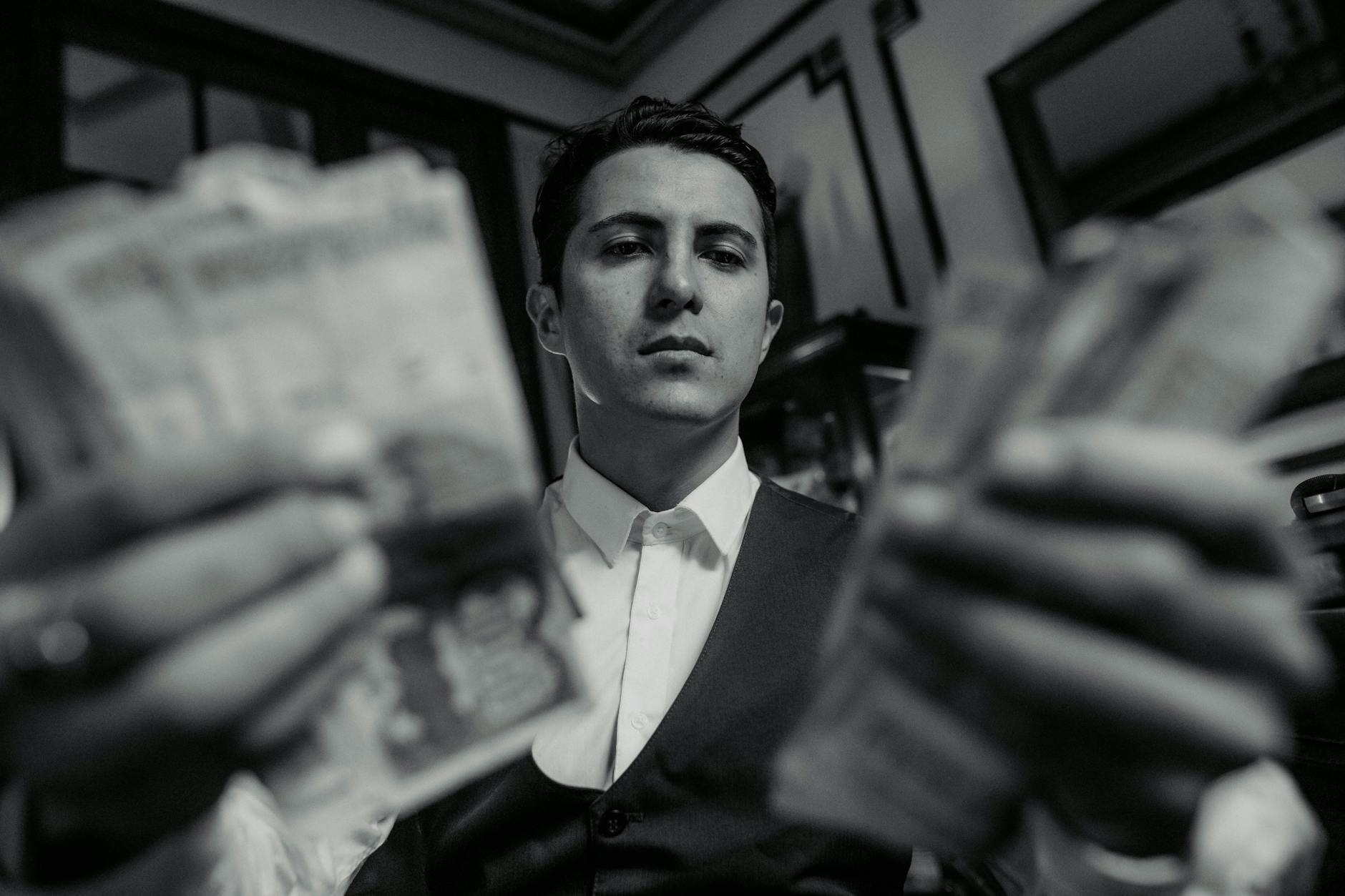 https://www.pexels.com/photo/man-in-white-shirt-and-vest-holding-cash-in-hands-22264652/