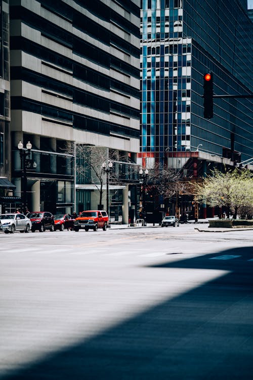 Cars Near Buildings With Red Traffic Light