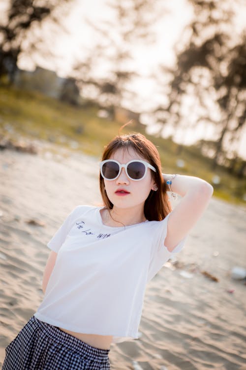 Photo of Woman in Sunglasses and White T-shirt Posing