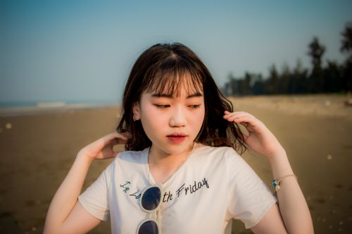 Free Portrait of a young woman with sunglasses at the beach on a sunny day, capturing relaxed elegance. Stock Photo