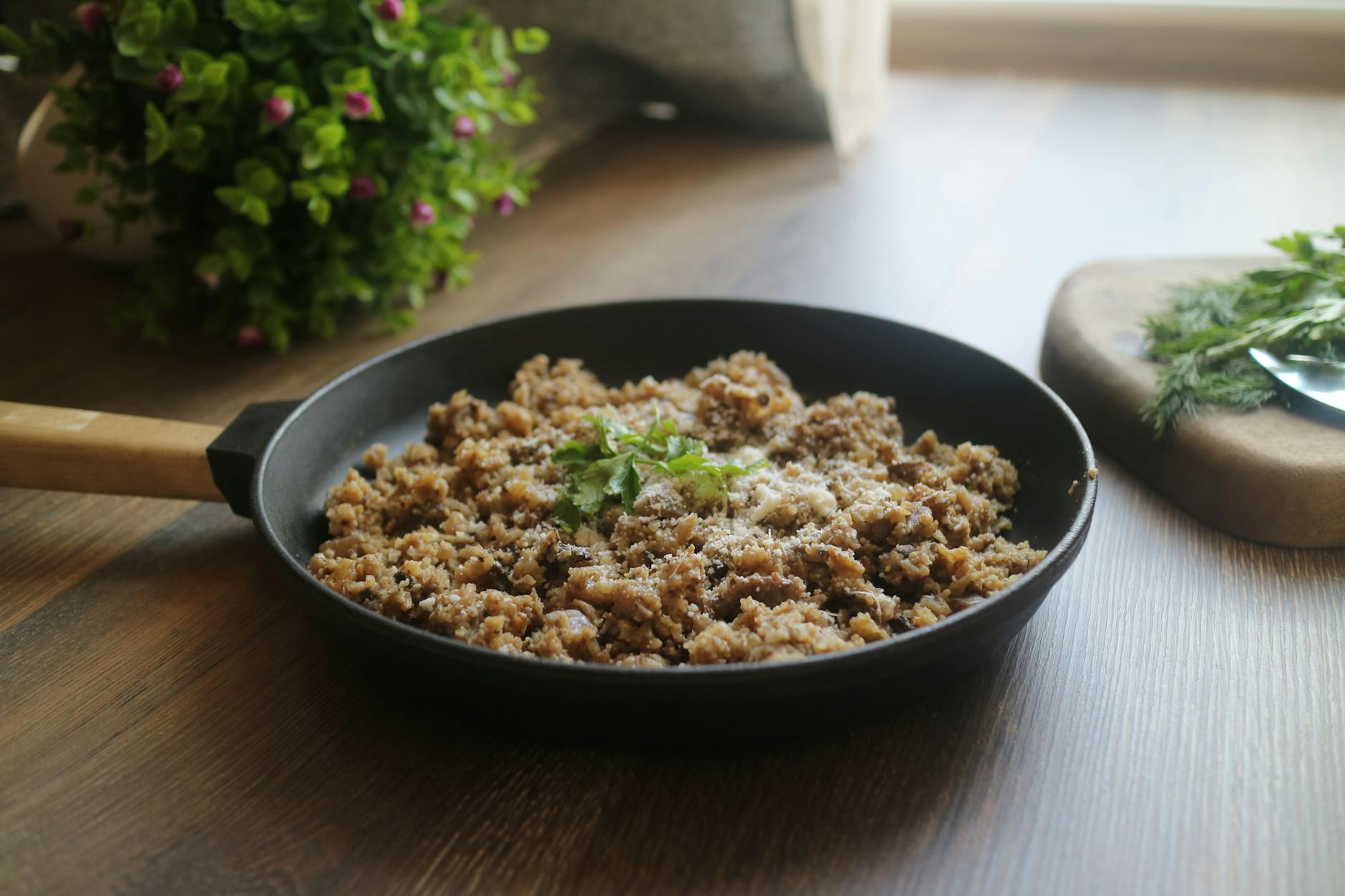 Tasty minced meat dish garnished with herbs in a black skillet, perfect for a delicious homemade meal.