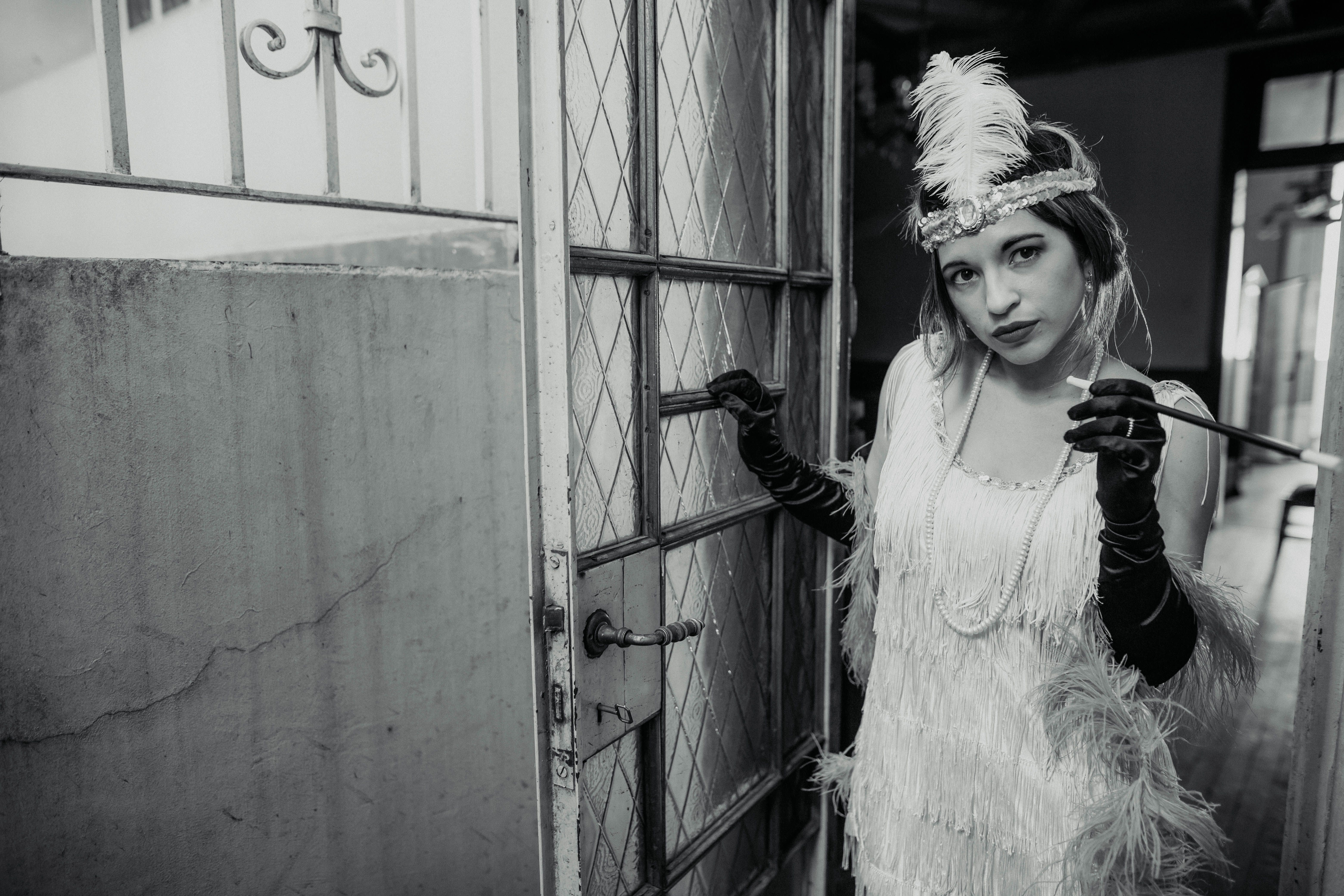 Black and white photo of a woman in 1920s flapper attire, exuding elegance in a Buenos Aires setting.