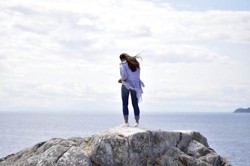 Free Woman Standing on Rock Stock Photo