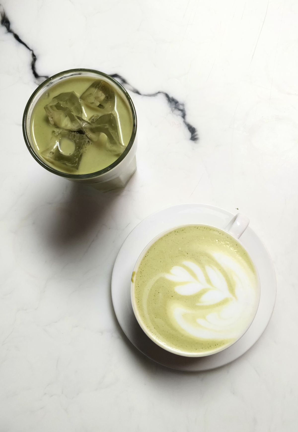 Iced Matcha und Matcha Latte auf Marmortisch – Koffeingehalt variiert je nach Zubereitung und Verhältnis