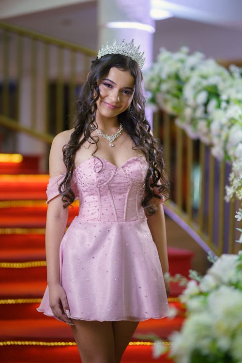 A young woman in a pink dress posing for the camera