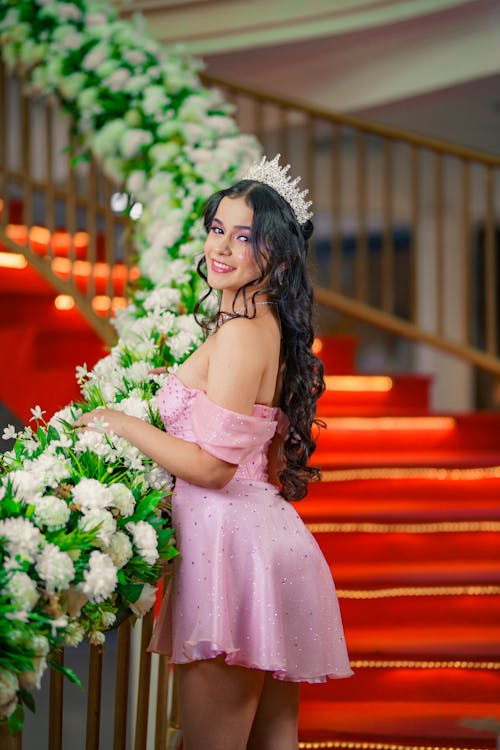 A woman in a pink dress posing on a staircase