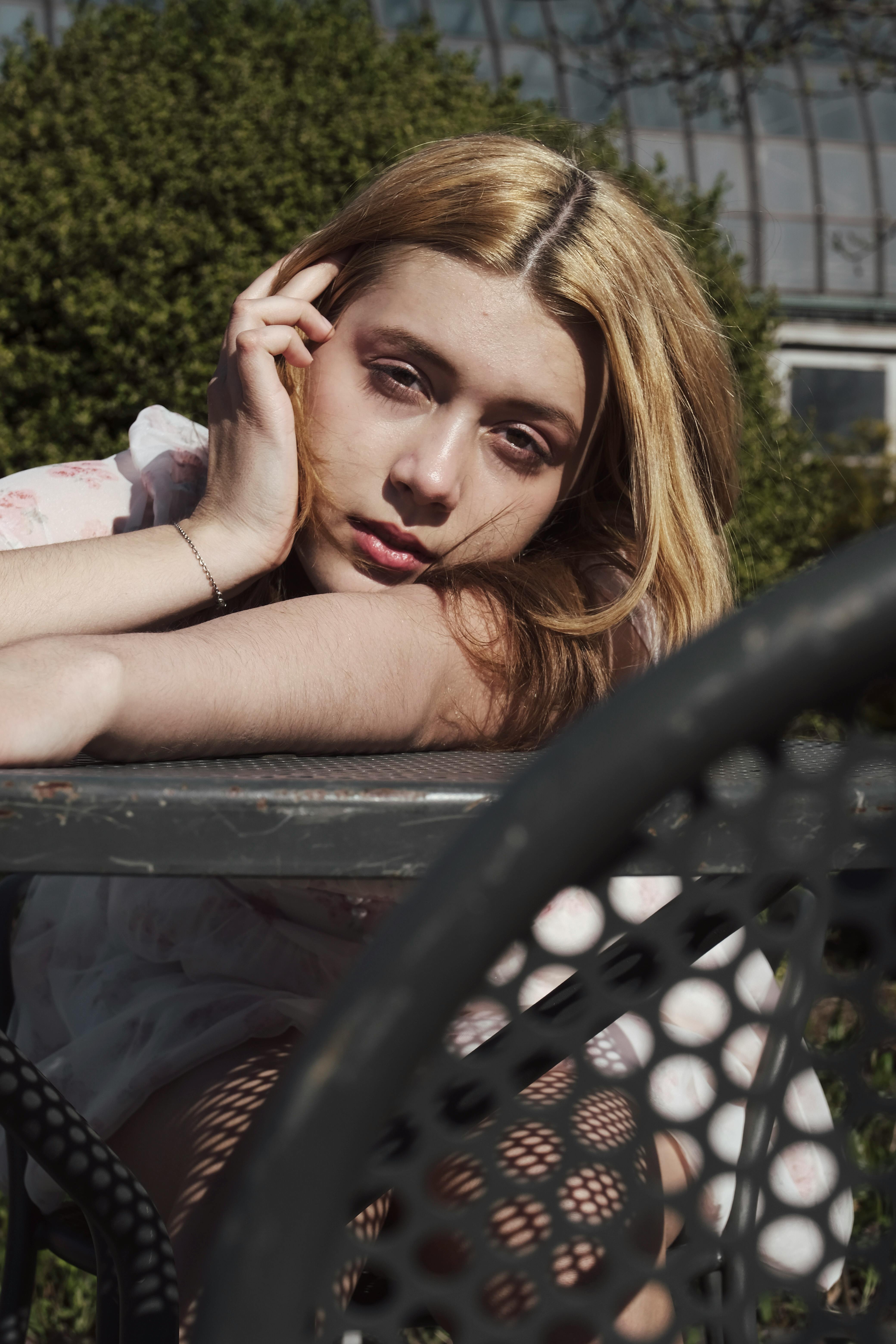 woman laying across park table