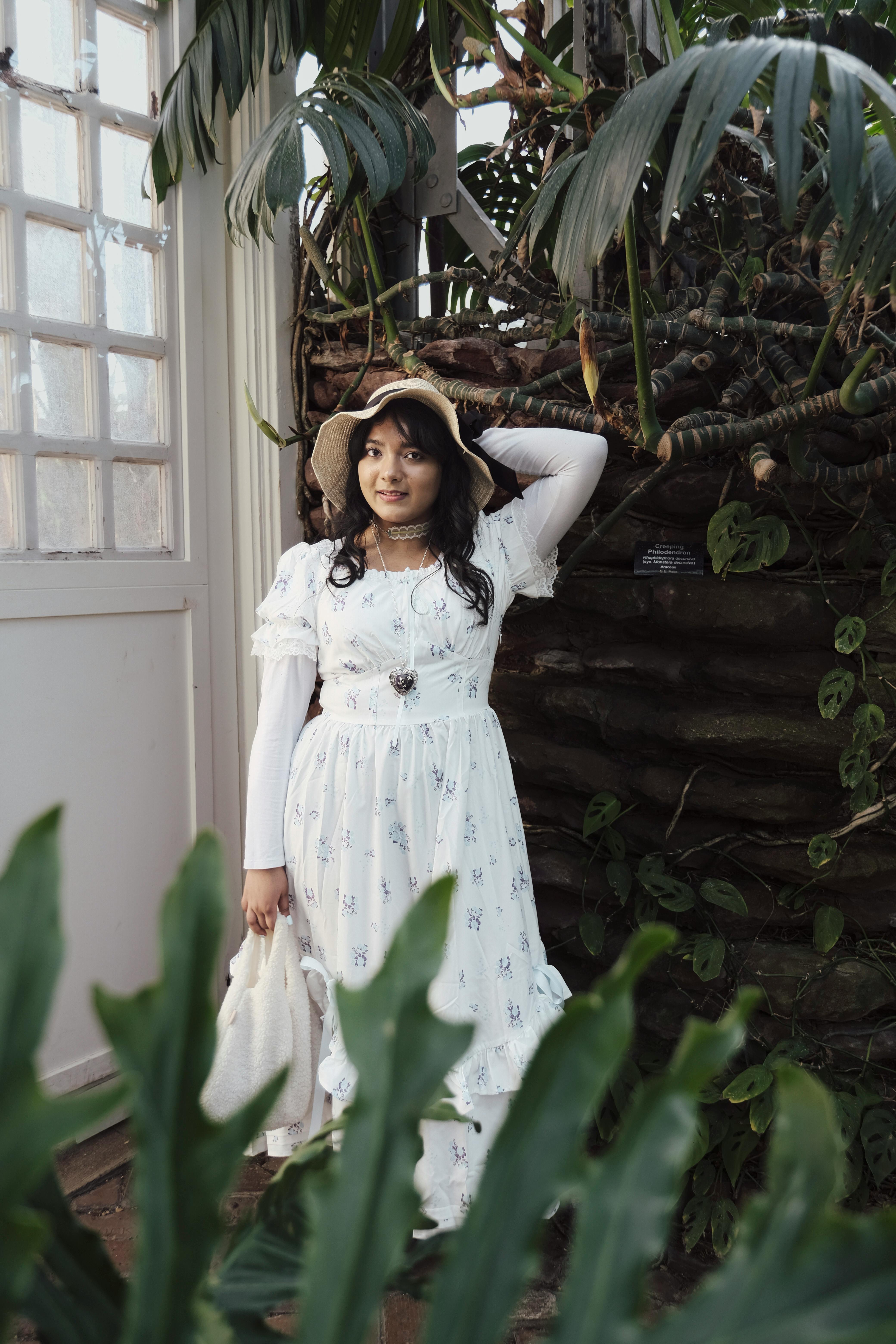 plants surrounding woman in dress