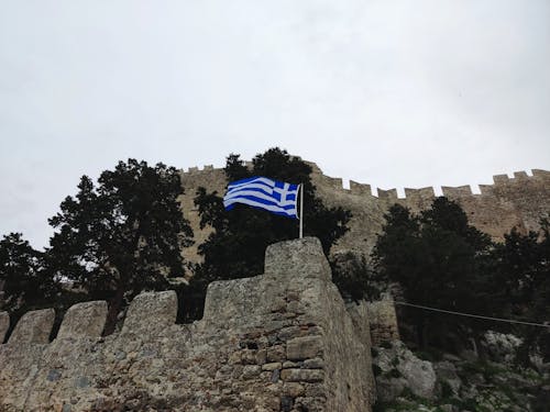 The Greek flag in front of an ancient castle in Rhodes