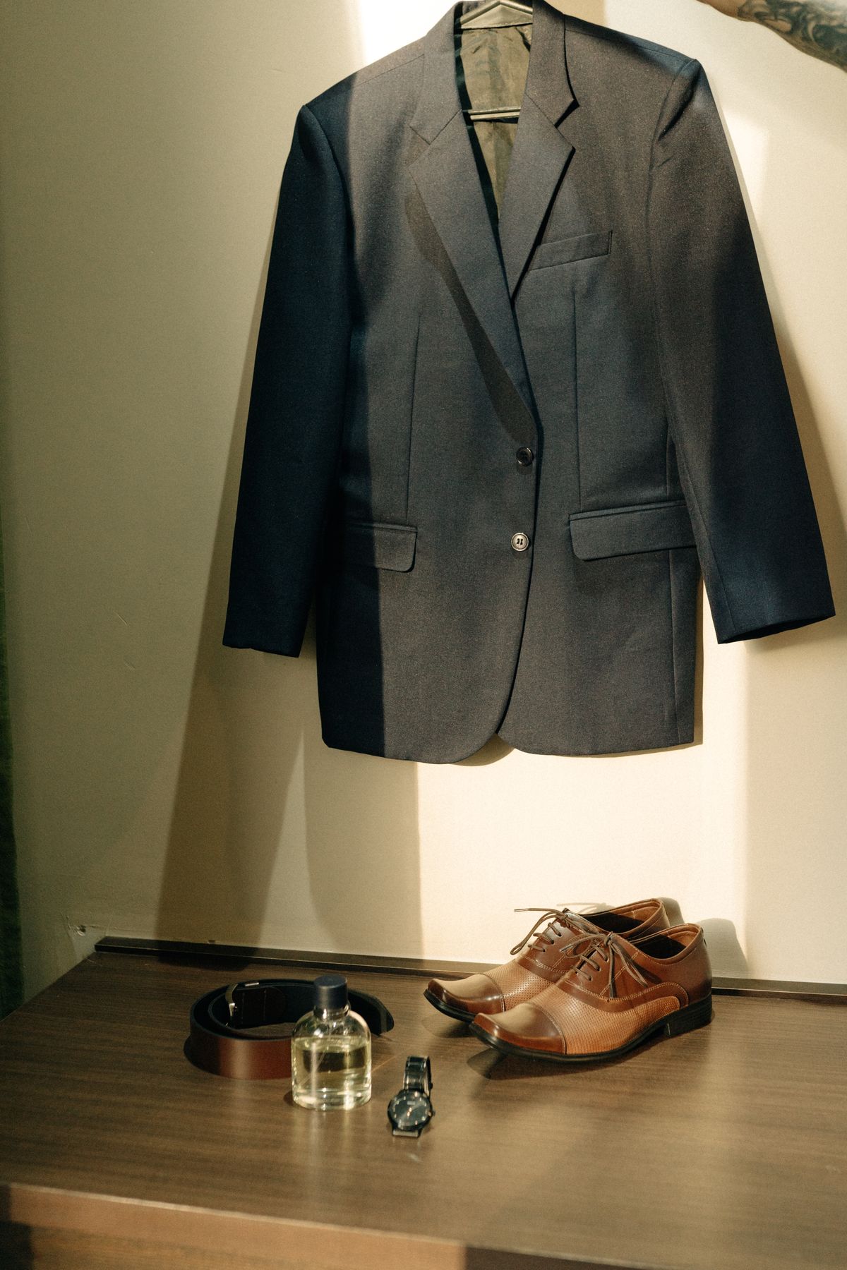 Look complet costume chemise chaussures posé sur meuble
