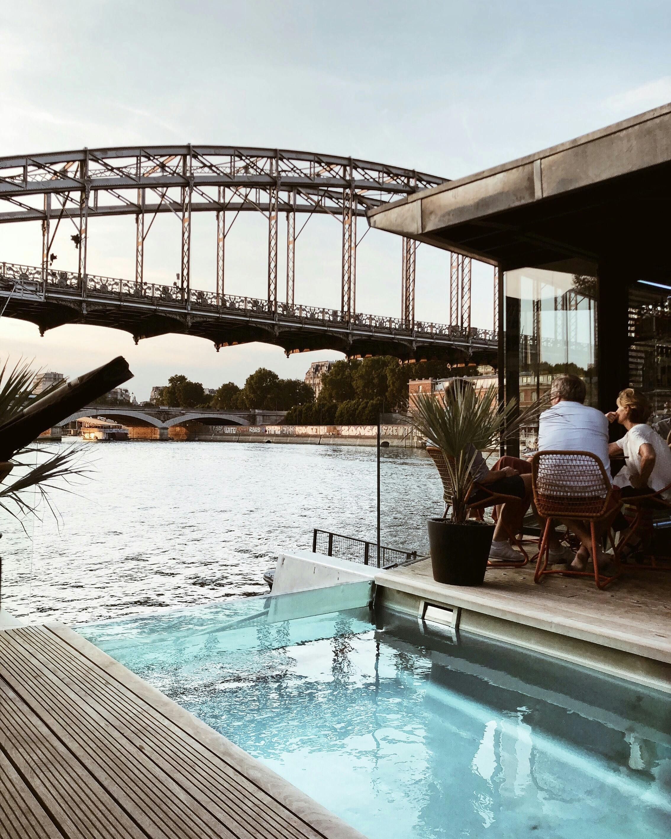 two person sitting beside pool