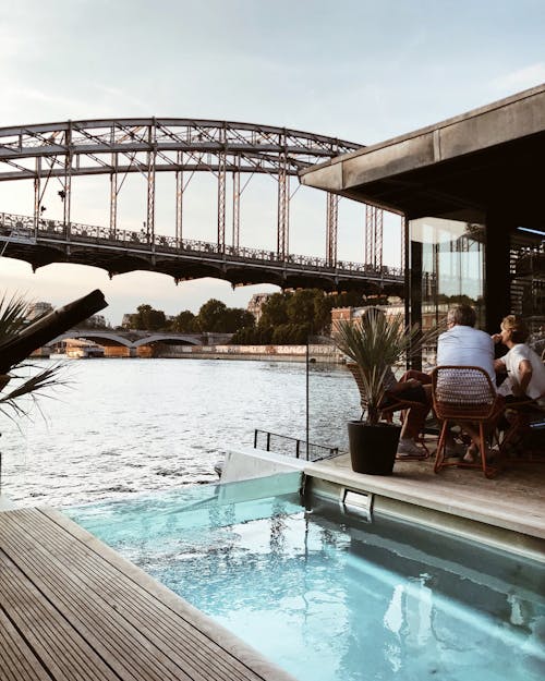 Two Person Sitting Beside Pool