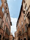 从低角度俯瞰，蓝天映衬下狭窄街道两旁的意大利历史建筑尽收眼底