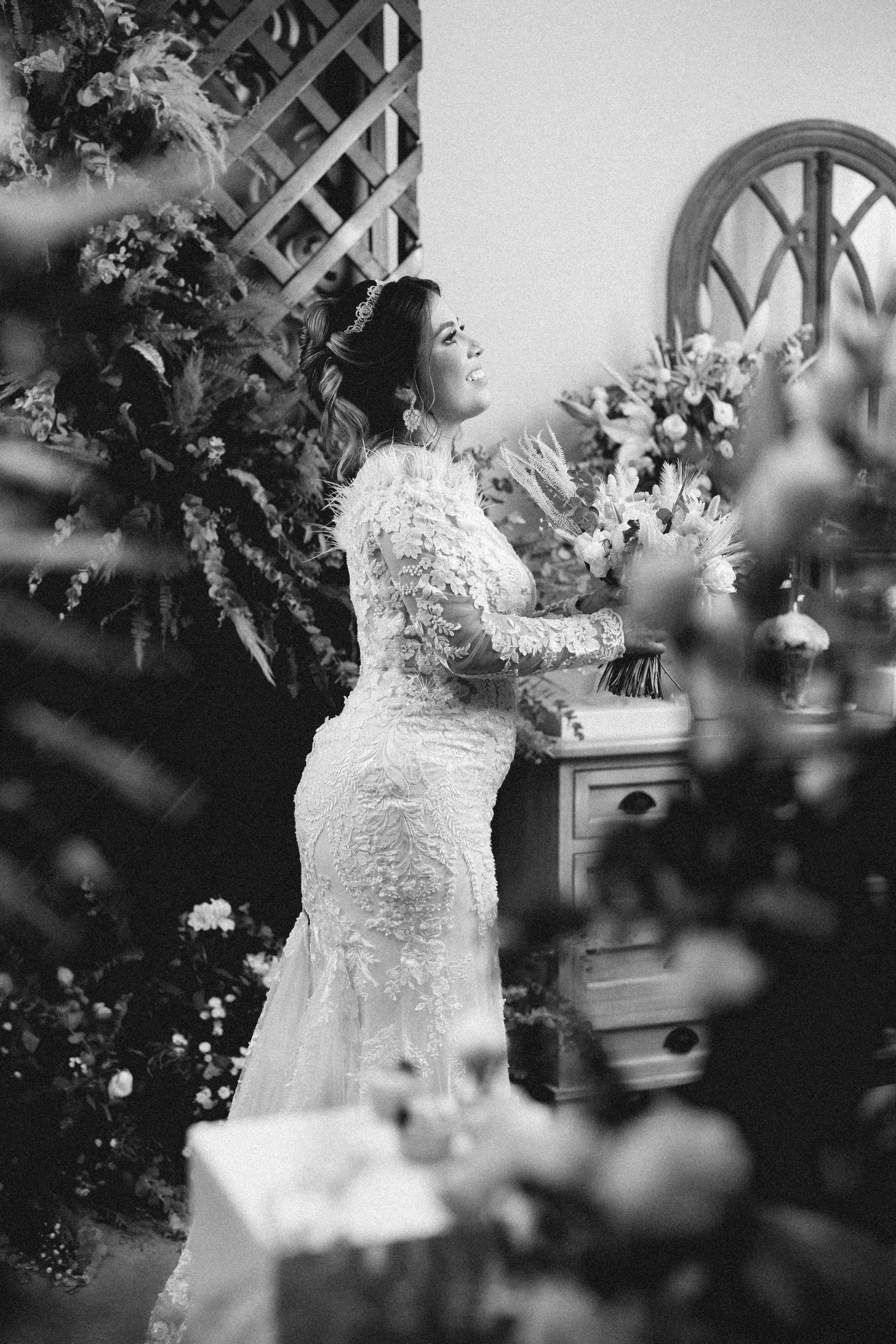 A stylish bride in a lace wedding dress enjoying her special day indoors.