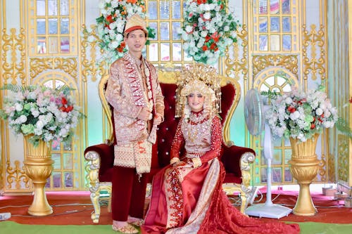 A man and woman in traditional attire posing for a photo