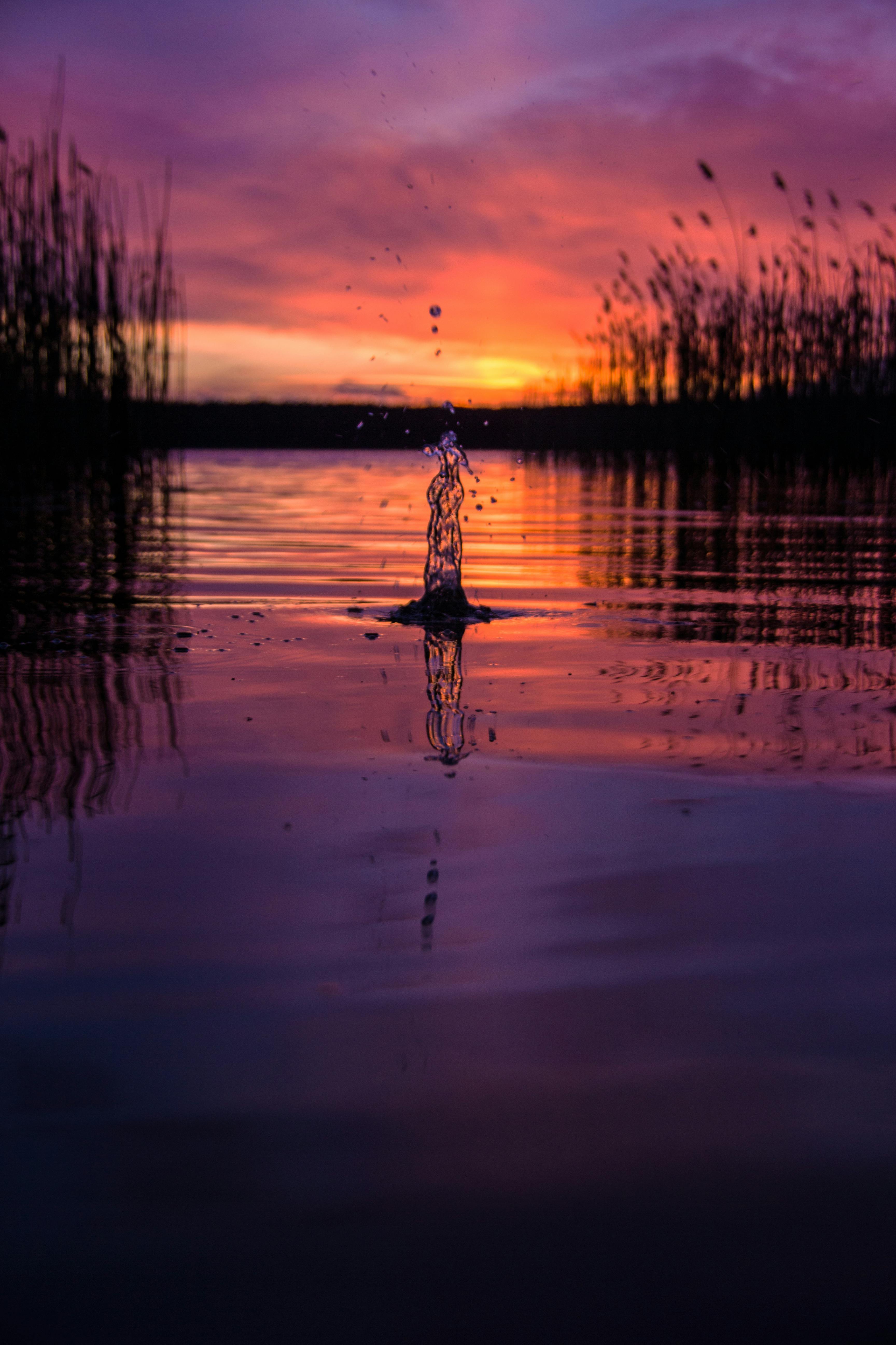 水面上映着令人惊叹的日落，倒影充满活力，莱茵斯堡的水花也显得格外戏剧性