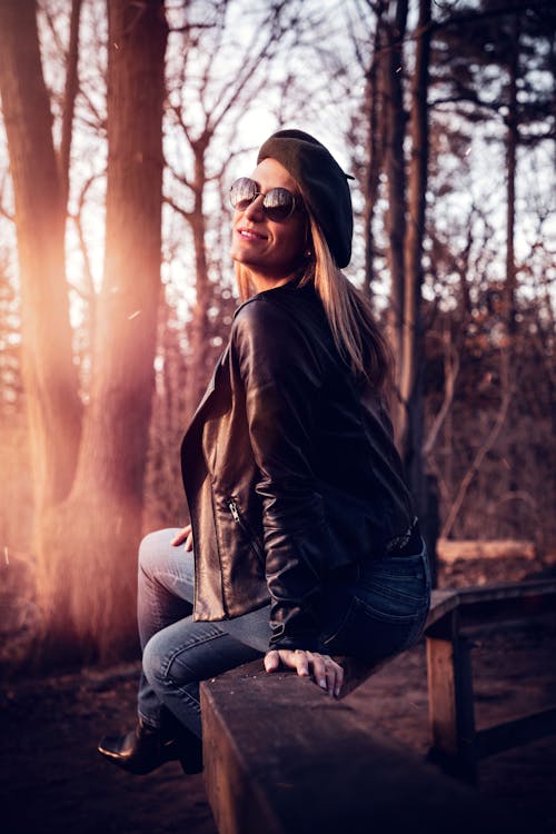 Photo of a Woman Sitting on Fence