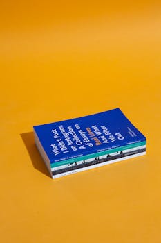 亮橙色背景的一堆书籍，非常适合教育主题