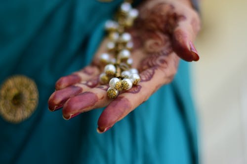 Photo of a Person's Hand Holding a Jewelry