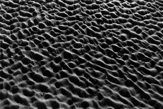 Captivating black and white image of textured sand patterns resembling natural abstract art.