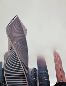 Foggy view of Moscow's iconic skyscrapers with modern architecture and twisted facades.