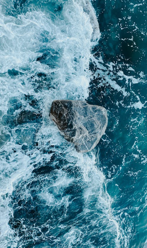 An aerial view of a rock in the ocean