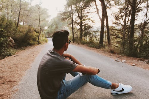 Vue Arrière Photo D'un Homme Assis Sur Une Route En Béton Gris