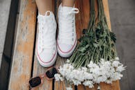 A woman's feet with white sneakers and flowers