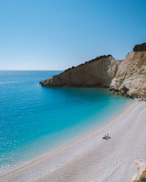 Photo of People Sitting on White Sand