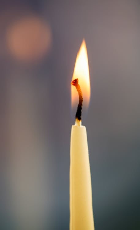 A candle is lit with a blurry background